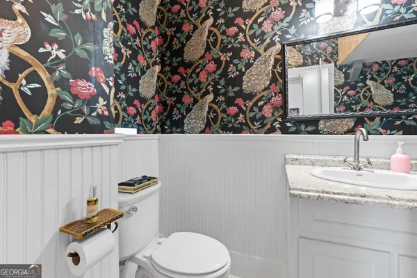 a bathroom with a toilet sink and mirror