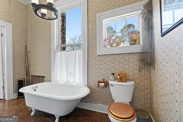 a bathroom with a toilet a sink and a shower curtain