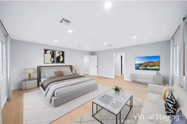 a spacious bedroom with a bed a couch and a view of kitchen