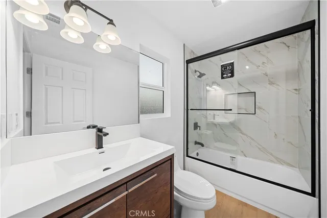 a bathroom with a sink a toilet and a large mirror