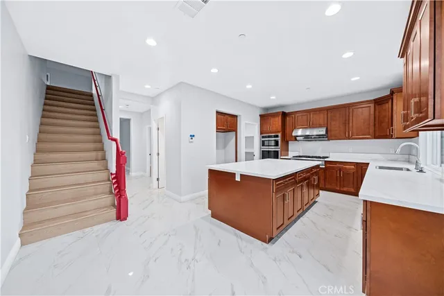 a large kitchen with stainless steel appliances granite countertop a large counter top and a stove top oven