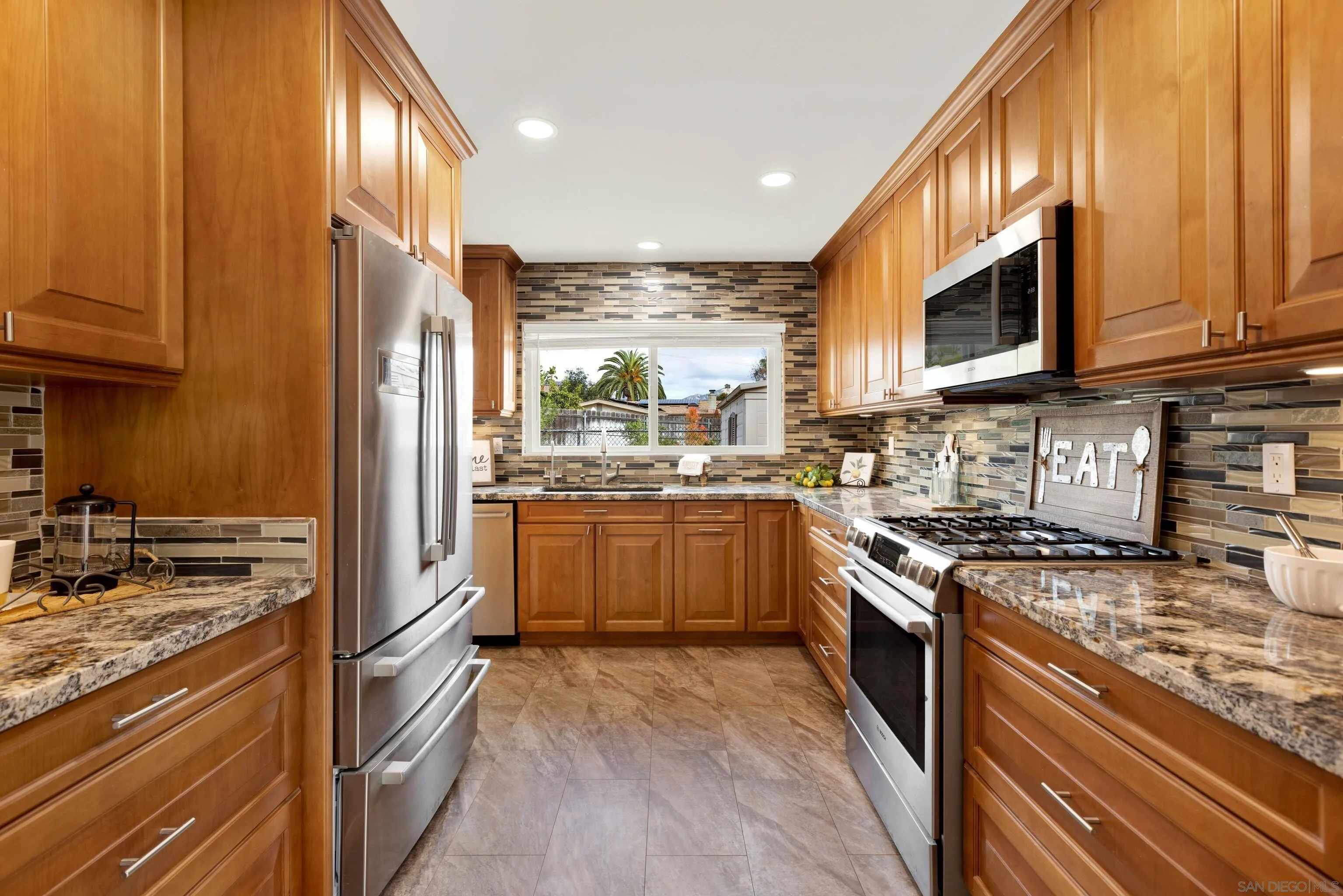 14545 Hillndale Way Poway, CA 92064 - Photo 20 of 52 a kitchen with stainless steel appliances granite countertop a stove top oven a sink dishwasher a refrigerator and cabinets with wooden floor