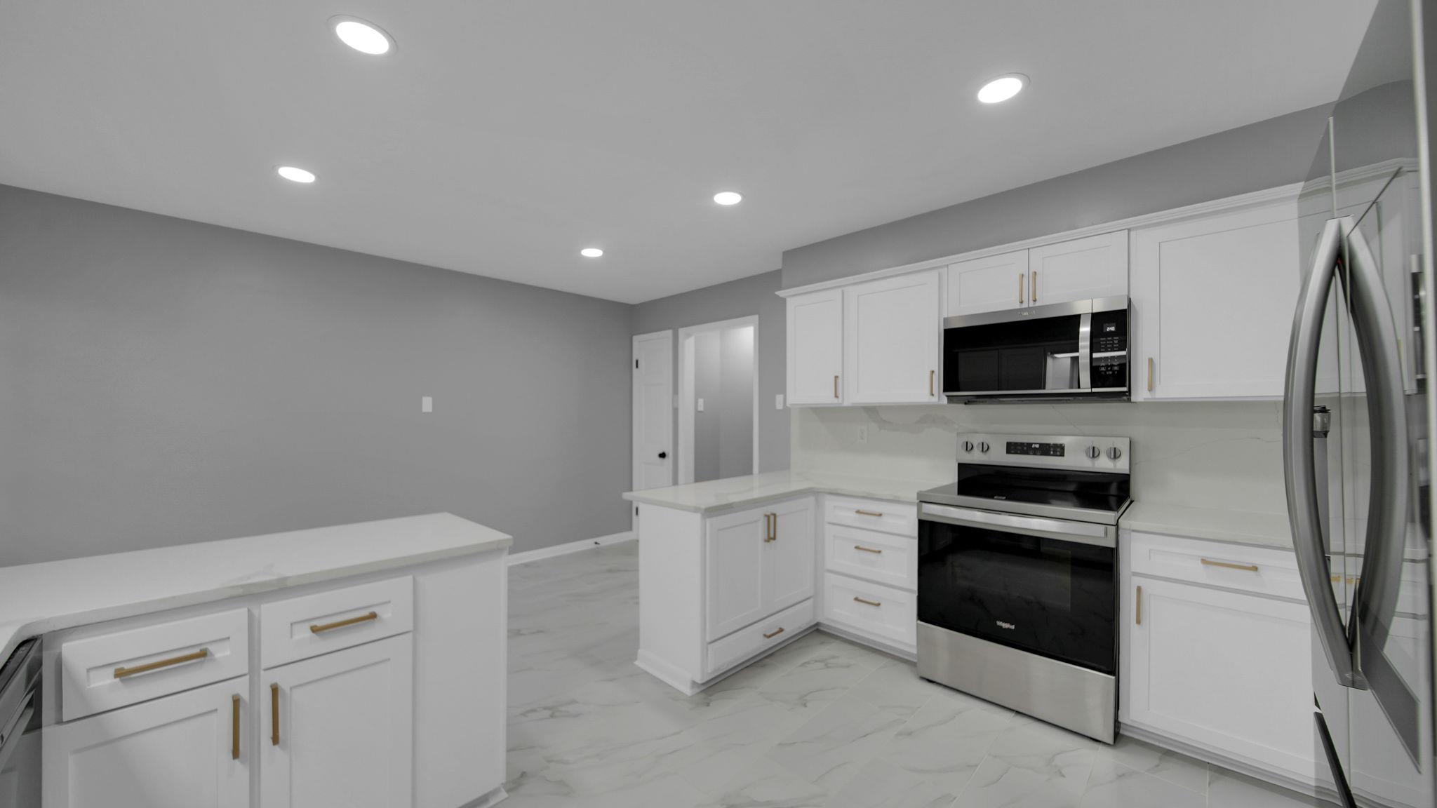 5256 Collingwood Road Memphis, TN 38117 - Photo 19 of 40 Kitchen featuring stainless steel appliances, a peninsula, white cabinetry, recessed lighting, and light marble finish floors