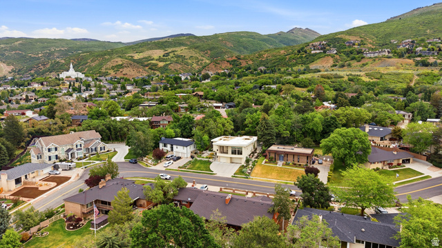 1389 Millbrook Way Bountiful, UT 84010 - Photo 69 of 74 Aerial perspective showcasing a residential neighborhood with diverse architectural styles, surrounded by lush, mature trees