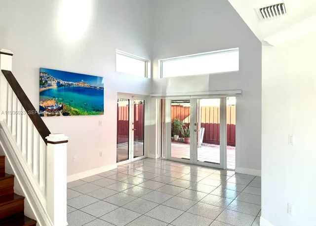 a view of a hallway with wooden floor and windows