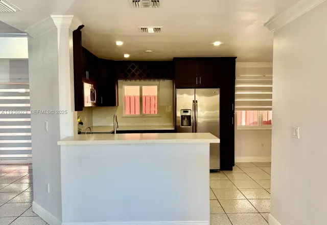 a view of a kitchen with a sink and a refrigerator