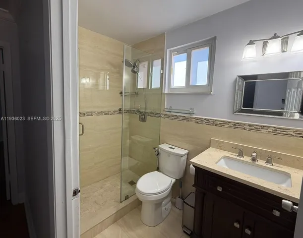 a bathroom with a toilet sink a mirror and shower