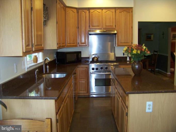 24 Farm Ridge Court Baldwin, MD 21013 - Photo 14 of 30 a kitchen with stainless steel appliances granite countertop a sink a stove and a refrigerator