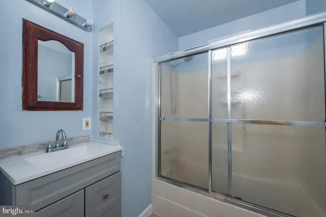 a bathroom with a shower sink and mirror