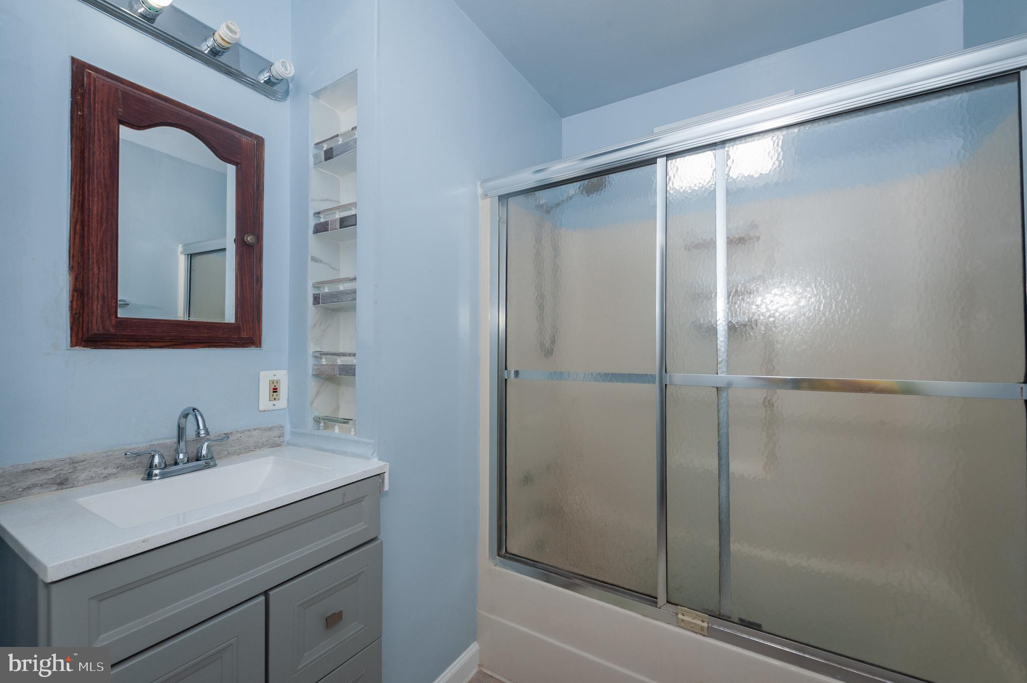 3729 Main Street Grasonville, MD 21638 - Photo 22 of 30 a bathroom with a shower sink and mirror