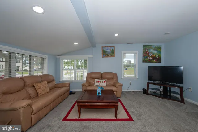 a living room with furniture a flat screen tv and a large window