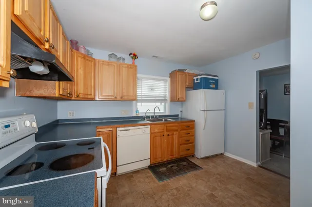 a kitchen with stainless steel appliances granite countertop a refrigerator a sink and wooden cabinets