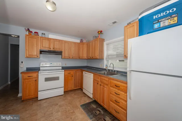 a kitchen with stainless steel appliances granite countertop a refrigerator sink stove and cabinets