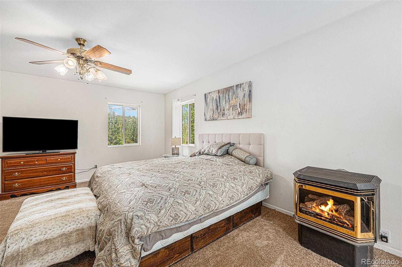 10142 South Turkey Creek Road Conifer, CO 80433 - Photo 18 of 48 a bedroom with a bed and a flat screen tv