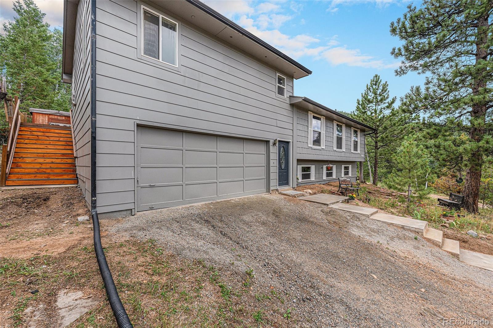 10142 South Turkey Creek Road Conifer, CO 80433 - Photo 6 of 48 a front view of a house with a yard and garage