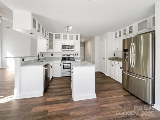 a kitchen with stainless steel appliances a refrigerator sink and cabinets