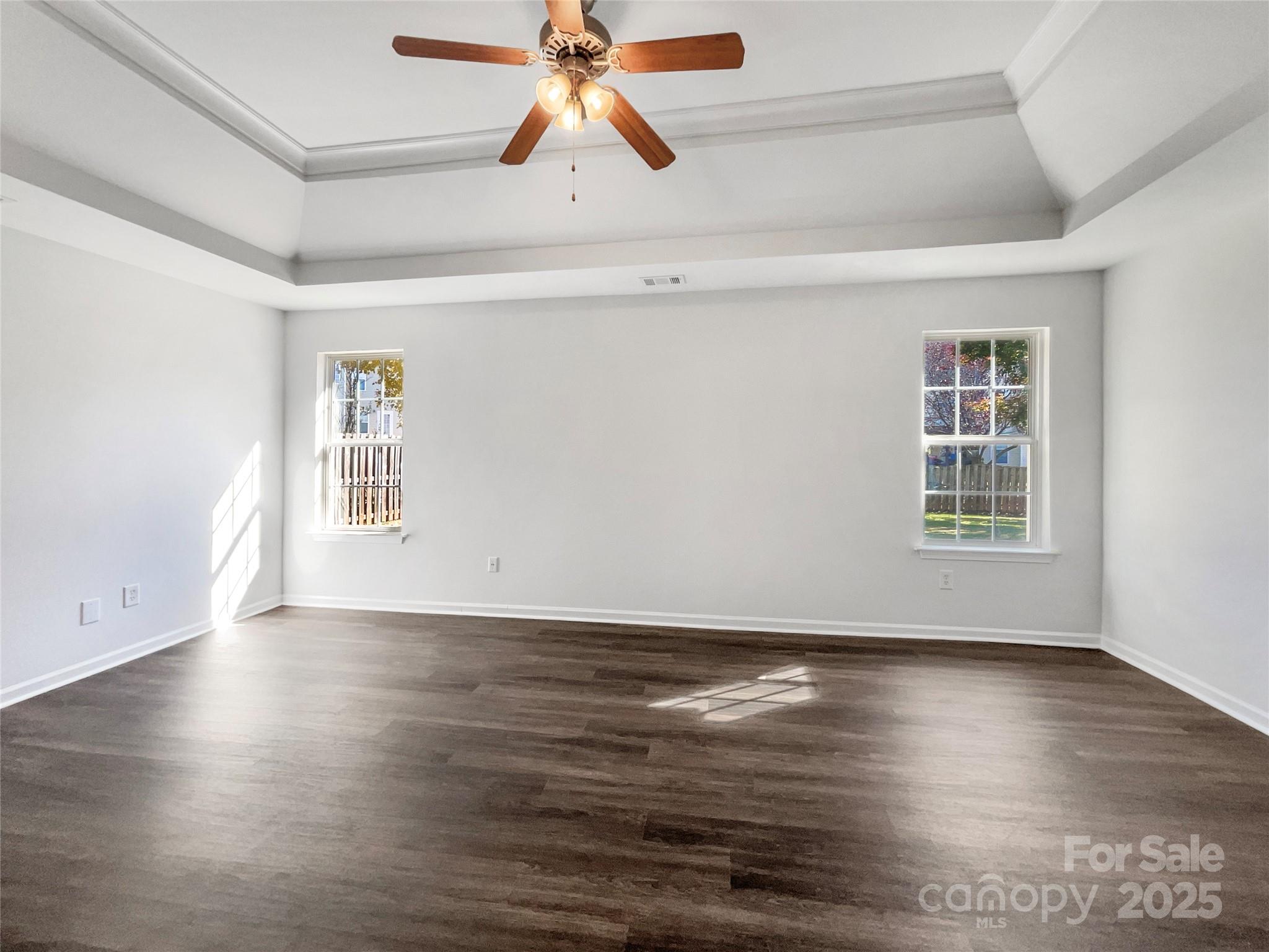 163 Scanlon Road Mooresville, NC 28115 - Photo 8 of 18 an empty room with wooden floor chandelier fan and windows