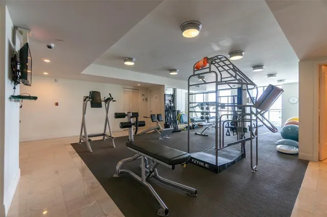 a room with gym equipment and wooden floor