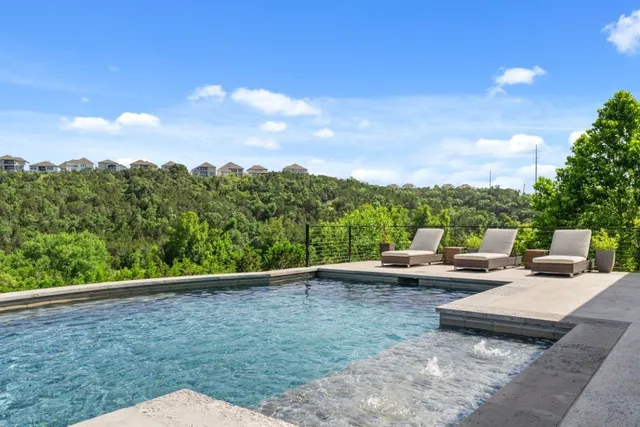 an aerial view of a house with yard and swimming pool