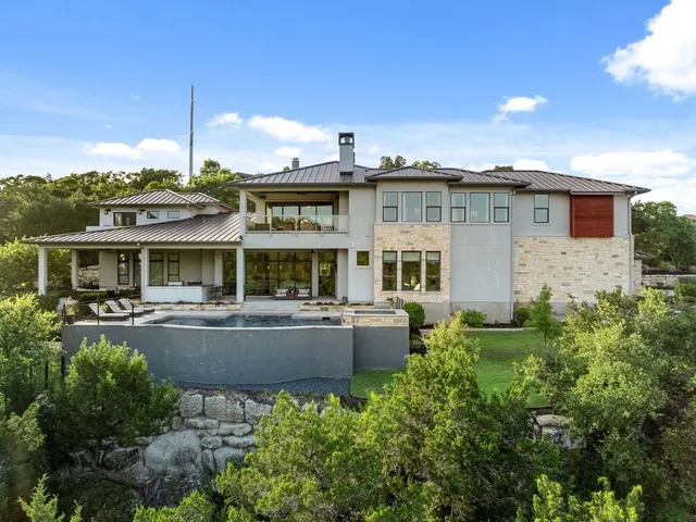 an aerial view of residential houses with outdoor space and trees