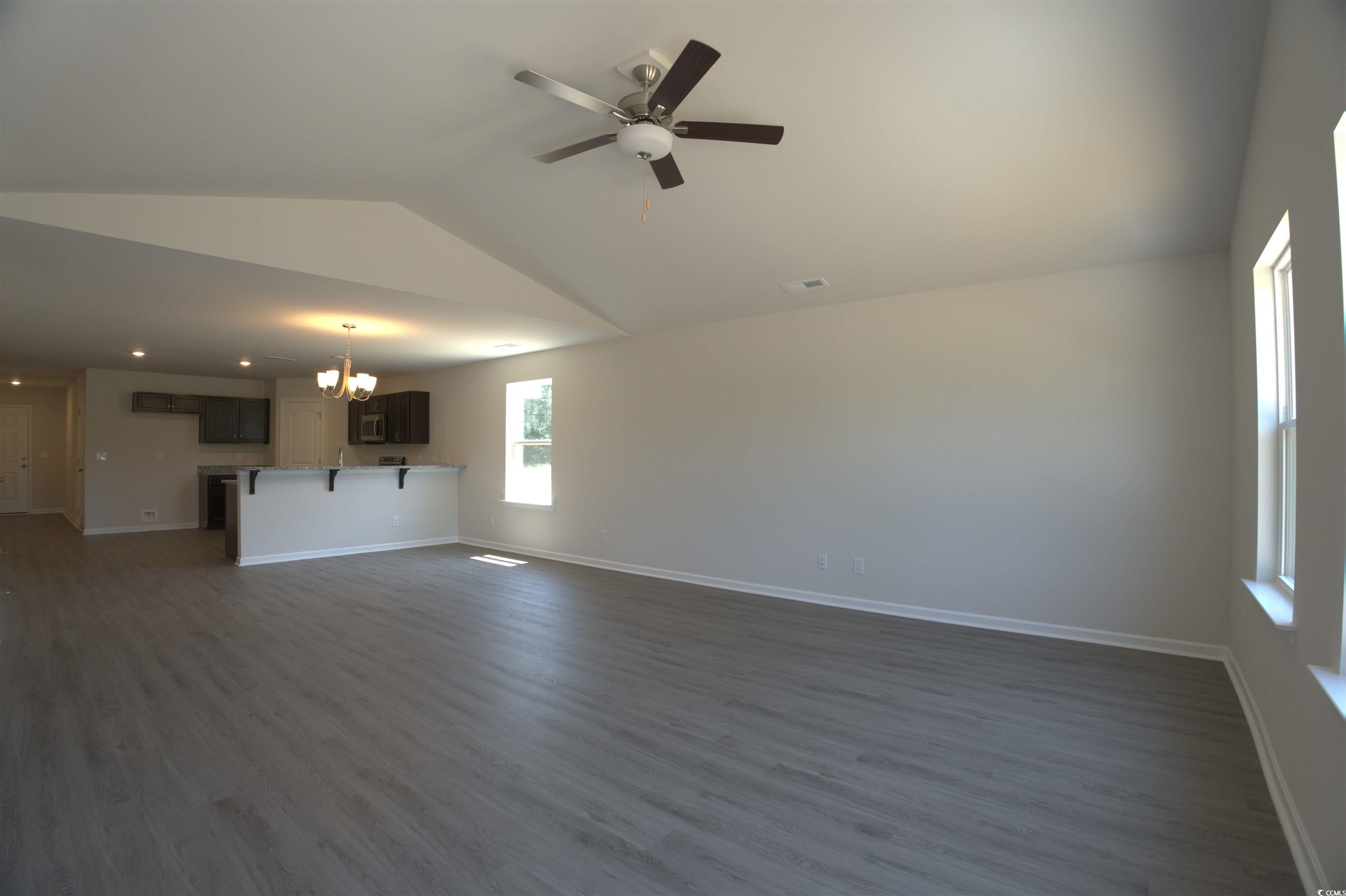 209 Kc Lane Aynor, SC 29511 - Photo 7 of 13 Unfurnished living room with vaulted ceiling, a chandelier, dark wood-style flooring, and a ceiling fan