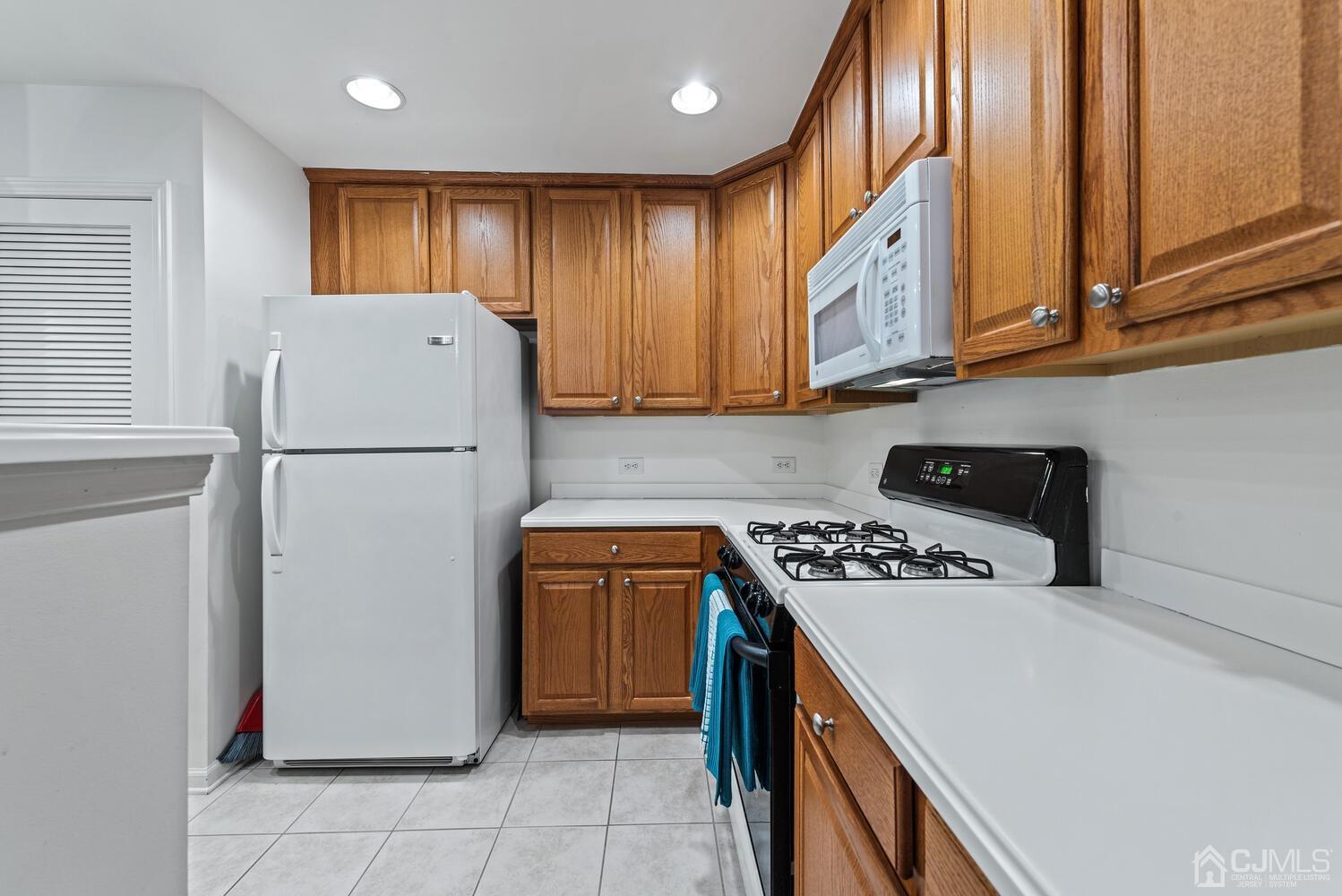 358 Rector Street, Unit 407 Perth Amboy, NJ 08861 - Photo 11 of 28 a kitchen with a refrigerator a stove top oven and cabinets