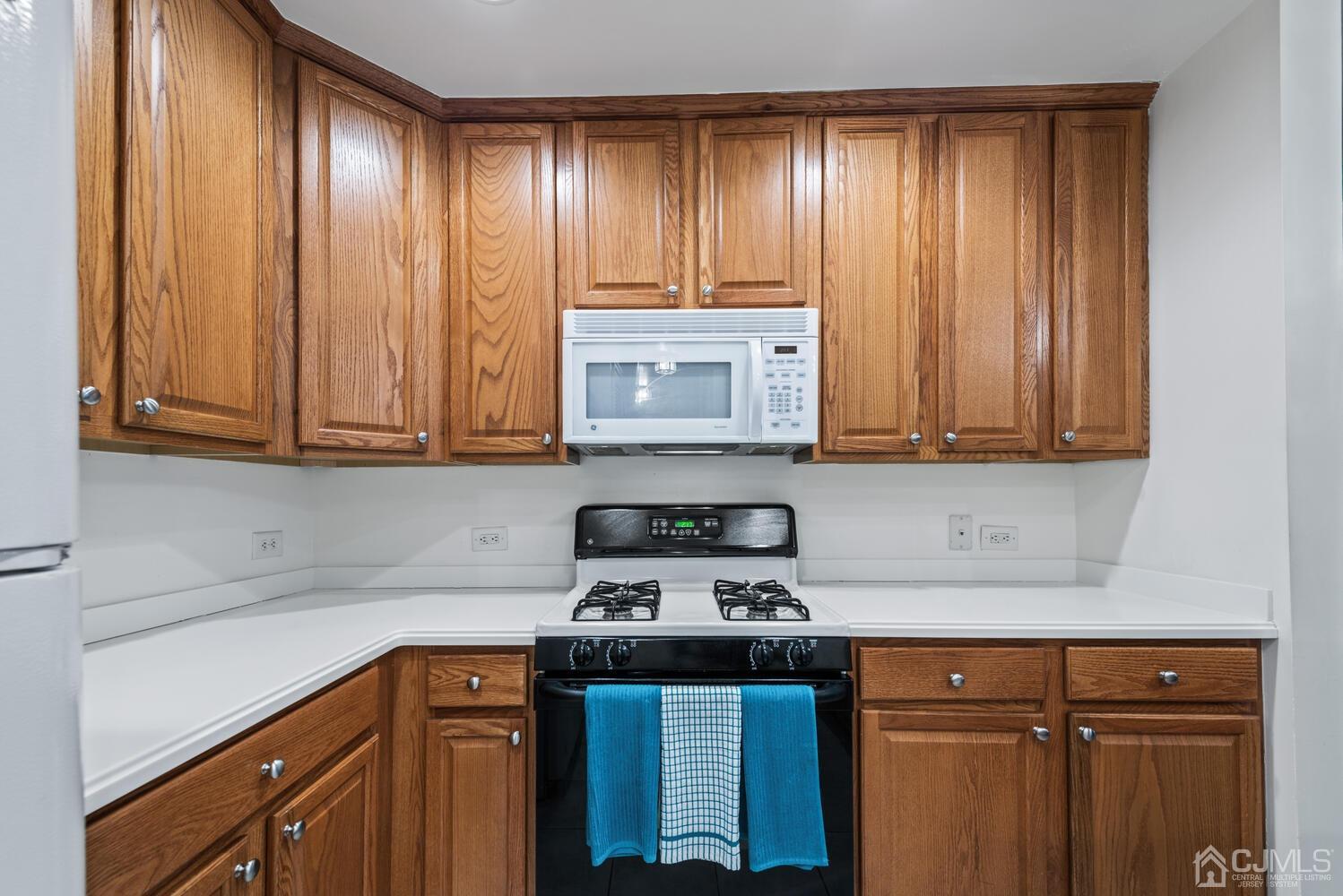 358 Rector Street, Unit 407 Perth Amboy, NJ 08861 - Photo 12 of 28 a kitchen with stainless steel appliances wooden cabinets and a stove top oven