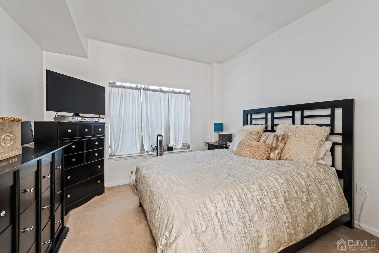 358 Rector Street, Unit 407 Perth Amboy, NJ 08861 - Photo 17 of 28 a bedroom with a bed and a flat screen tv