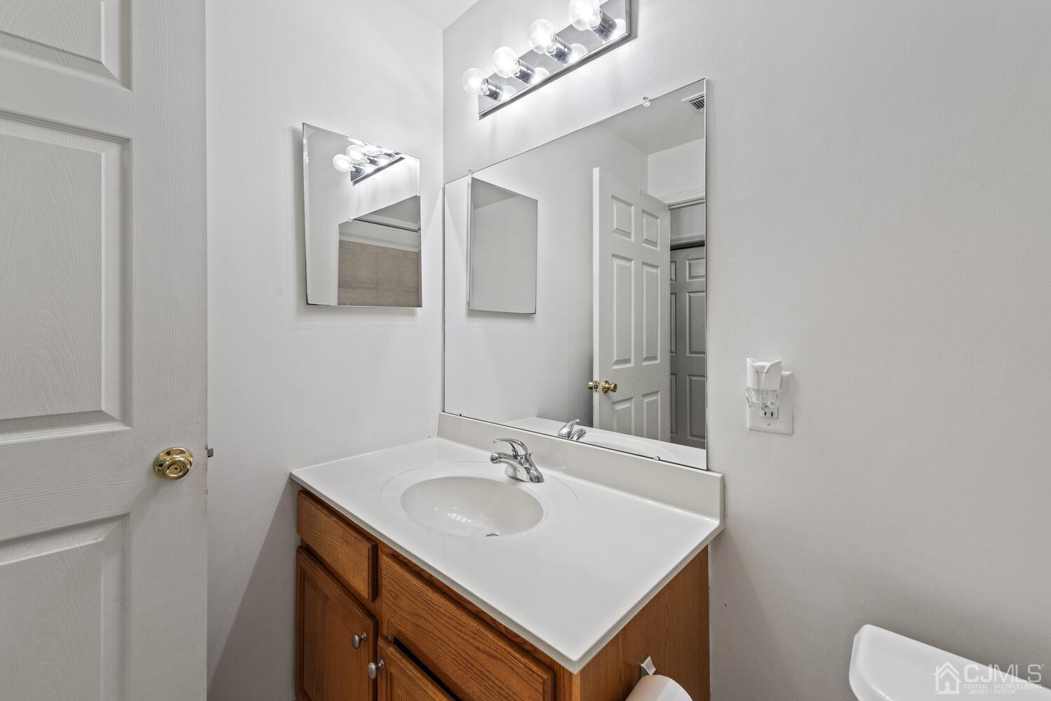 358 Rector Street, Unit 407 Perth Amboy, NJ 08861 - Photo 22 of 28 a bathroom with a sink a toilet and mirror