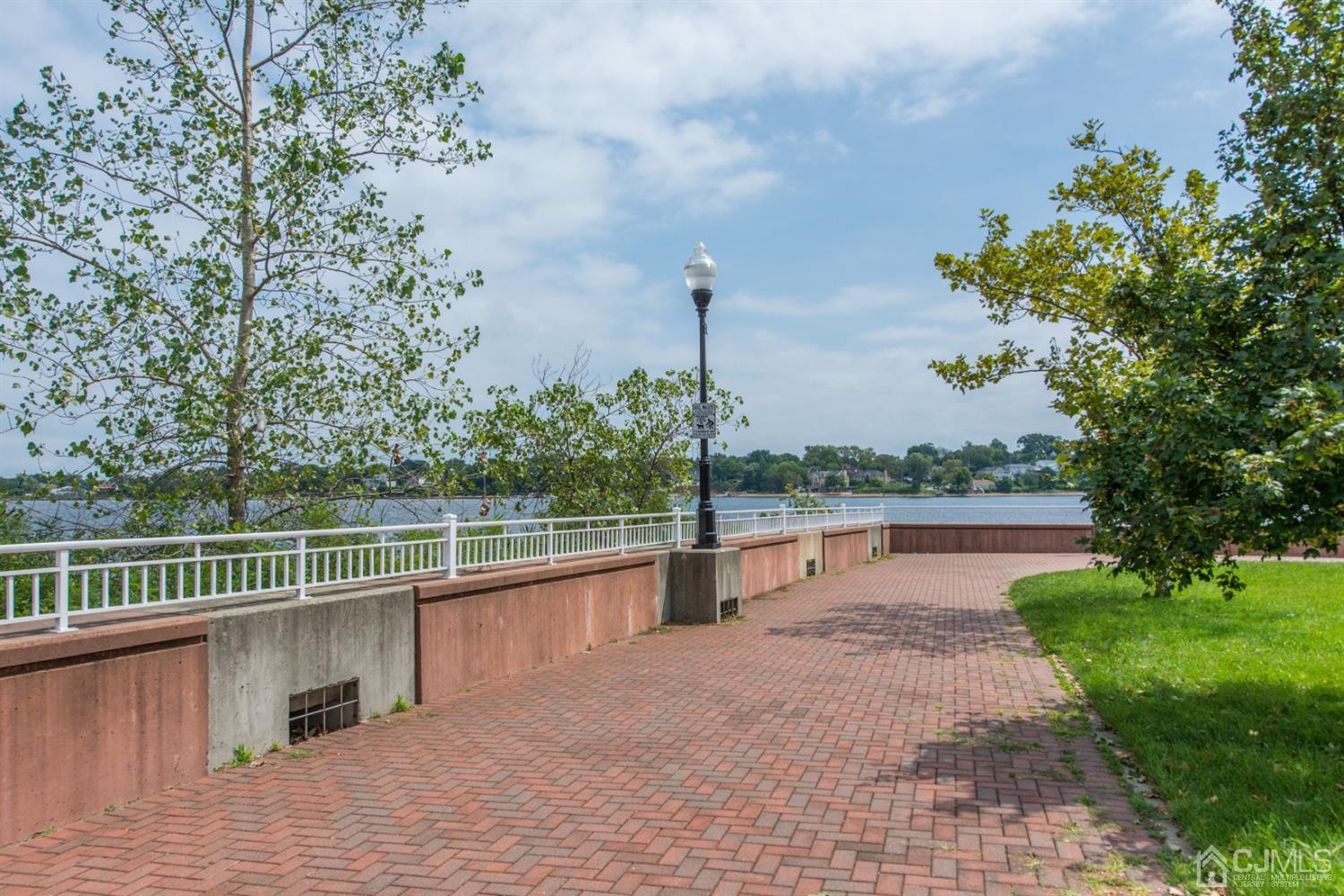 358 Rector Street, Unit 407 Perth Amboy, NJ 08861 - Photo 26 of 28 a view of a lake with a garden and a large tree