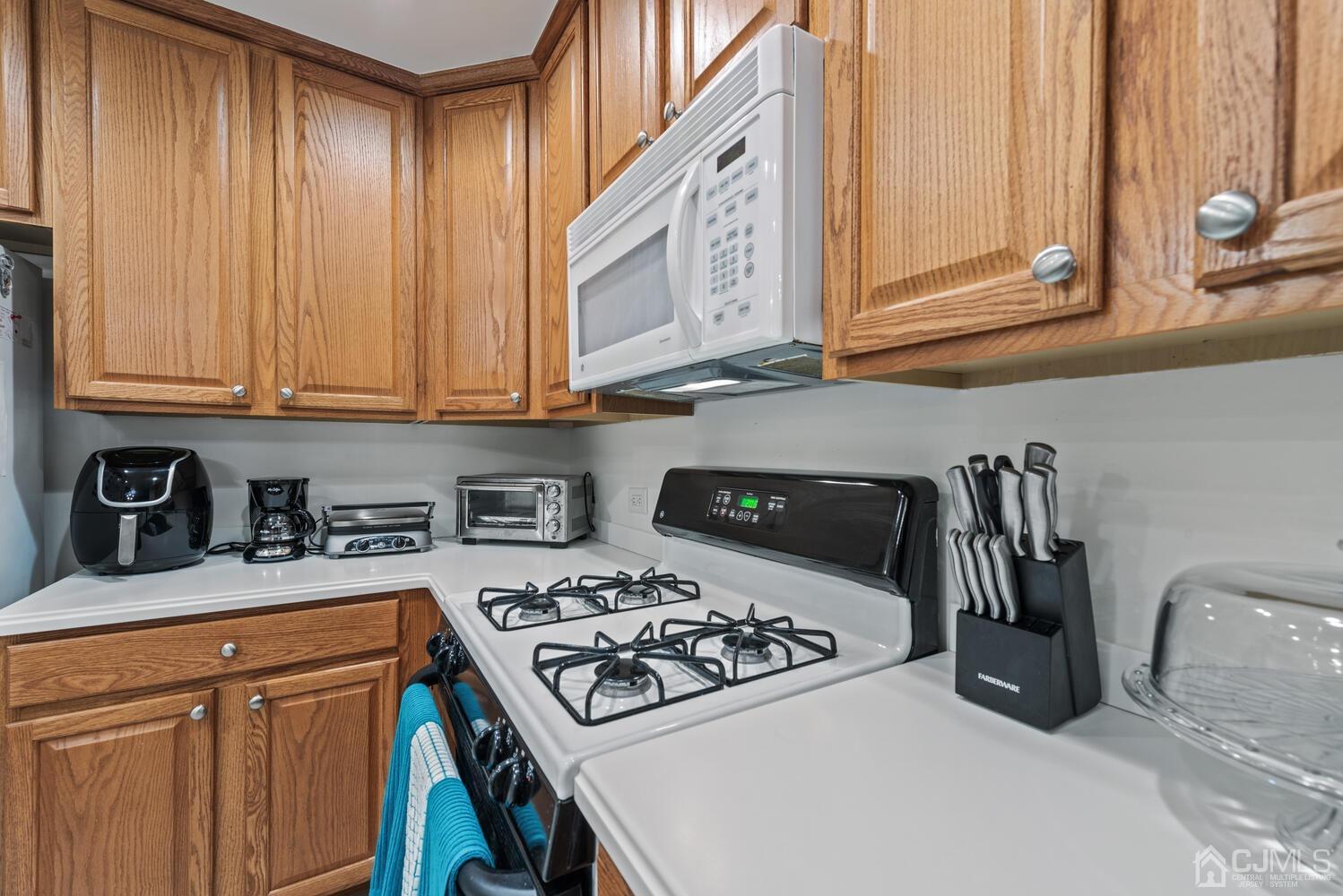 358 Rector Street, Unit 407 Perth Amboy, NJ 08861 - Photo 9 of 28 a kitchen with stainless steel appliances granite countertop a stove a sink and a microwave