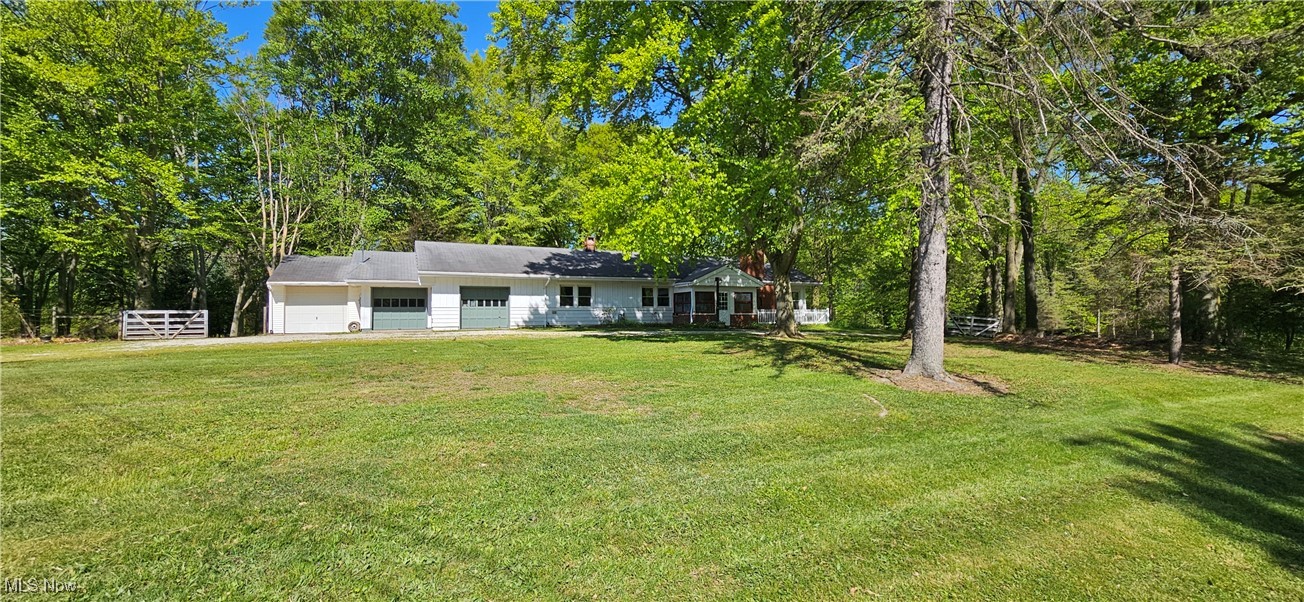 Front view of house with a yard and garages