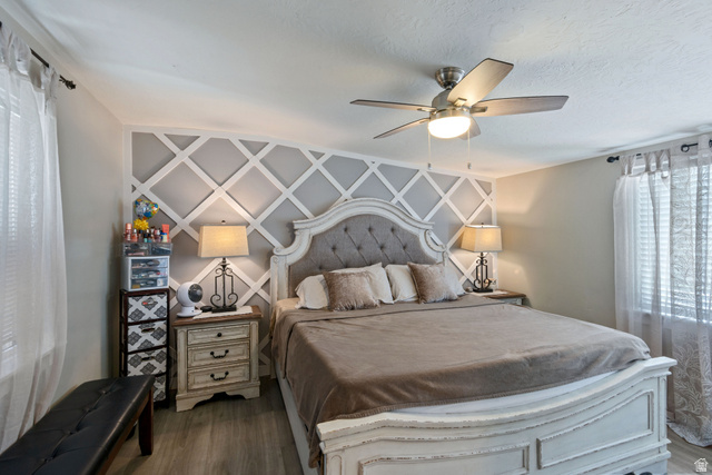 255 North 1600 West, Unit 60 Provo, UT 84601 - Photo 16 of 22 Bedroom featuring ceiling fan, dark wood-style flooring, and an accent wall