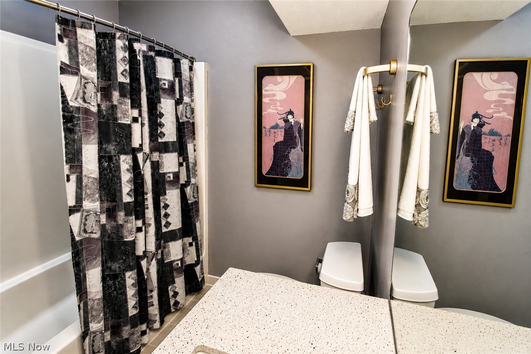 16575 Wren Road, Unit 3C Chagrin Falls, OH 44023 - Photo 23 of 29 Also features a built-in bathtub with a handheld shower kit and gleaming white ceramic tile floor
