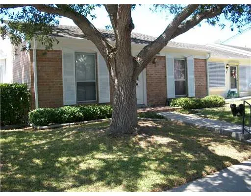 a tree in front of a white house