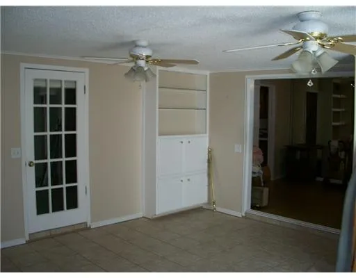 an empty room with windows and cabinet