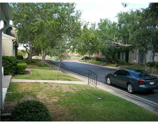 a view of a yard with a car parked in the background
