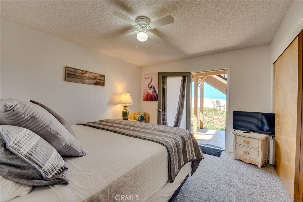 1612 Strand Way Oceano, CA 93445 - Photo 8 of 27 a bedroom with a bed and a chandelier
