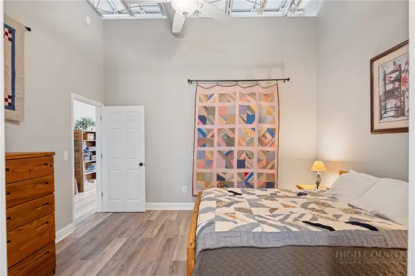 a bedroom with a bed and wooden floor