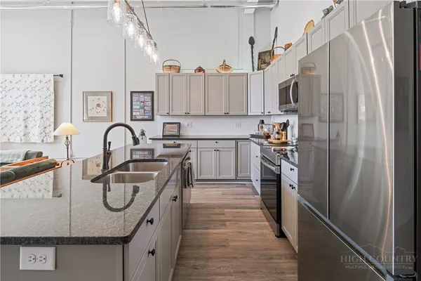 a kitchen with stainless steel appliances granite countertop a stove a sink and white cabinets