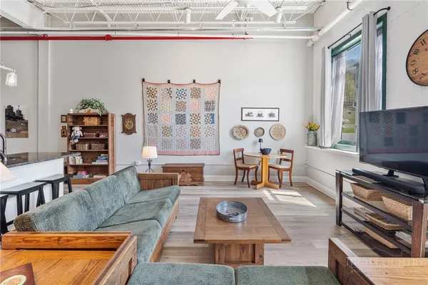 a living room with furniture a flat screen tv and a window
