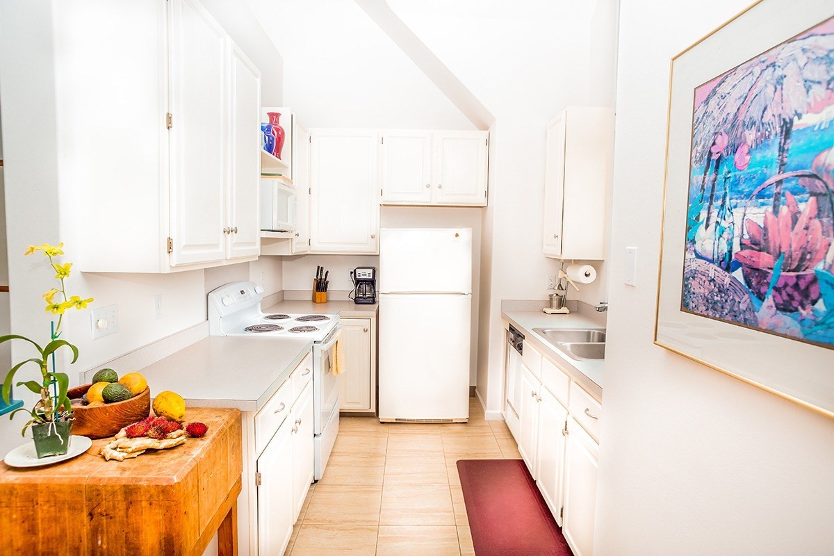 5001 Kikala Road, Unit 1 Kalaheo, HI 96741 - Photo 6 of 14 a kitchen with granite countertop a white stove top oven and sink