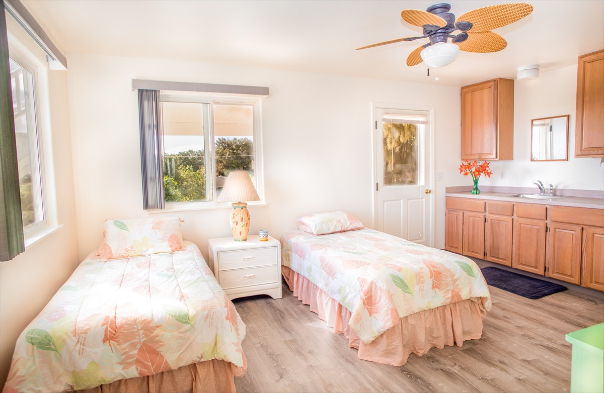 5001 Kikala Road, Unit 1 Kalaheo, HI 96741 - Photo 9 of 14 a bedroom with a bed and a chandelier