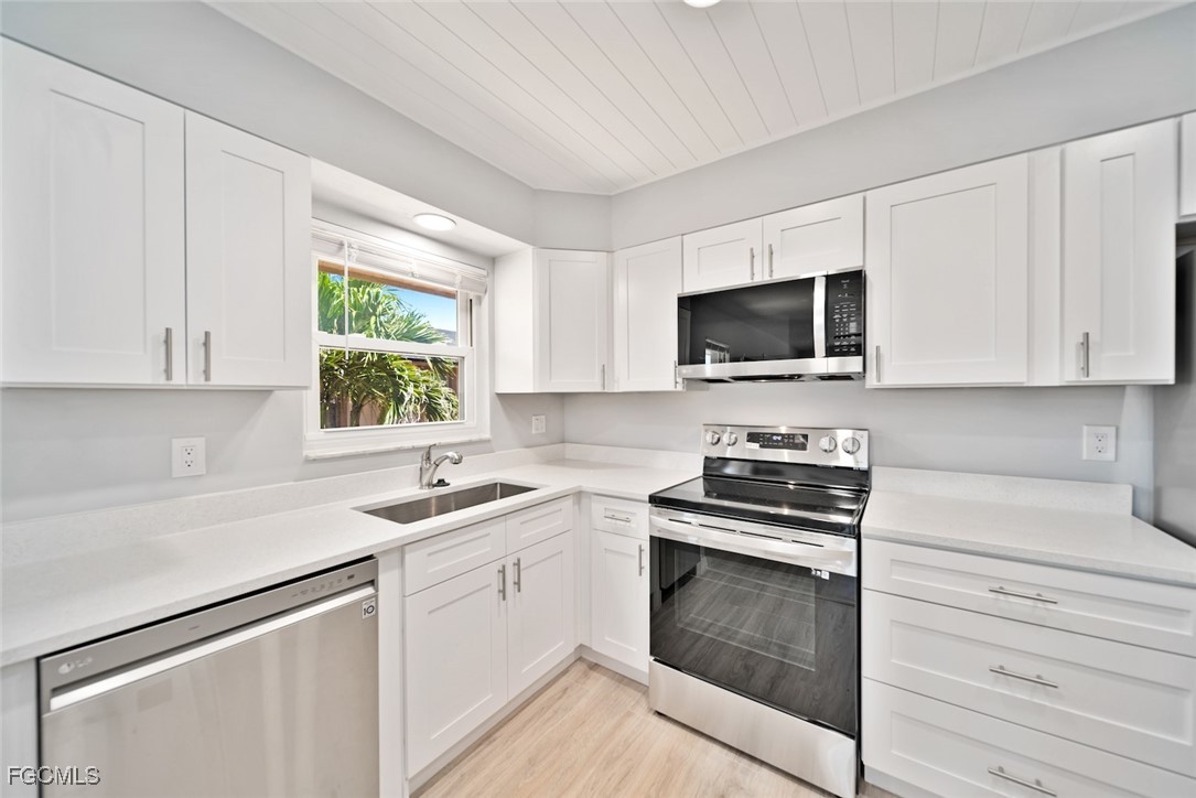 16881 Davis Road, Unit 721 Fort Myers, FL 33908 - Photo 10 of 23 a kitchen with white cabinets appliances and a sink