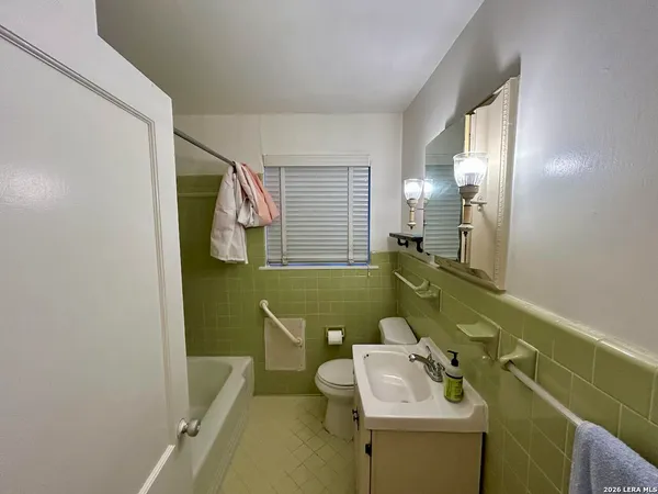 a bathroom with a sink mirror and a bathtub