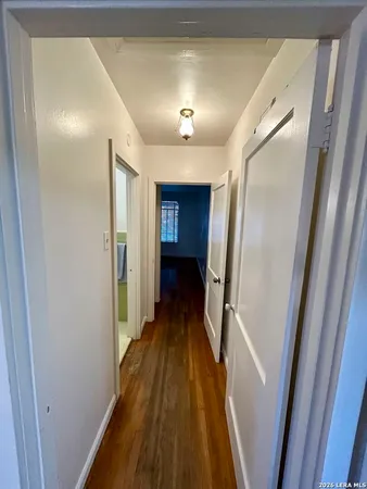a view of a hallway with wooden floor and staircase