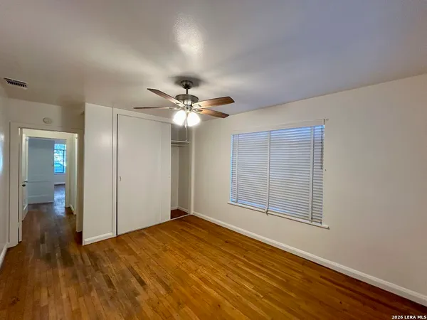 a view of an empty room with wooden floor