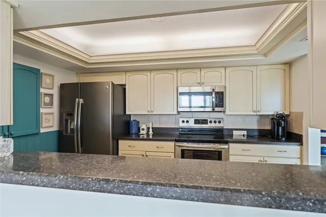 a kitchen with stainless steel appliances kitchen island granite countertop a refrigerator a stove and a sink with wooden floor