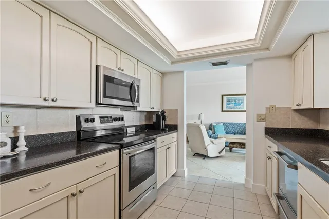 a kitchen with granite countertop a sink a stove and cabinets
