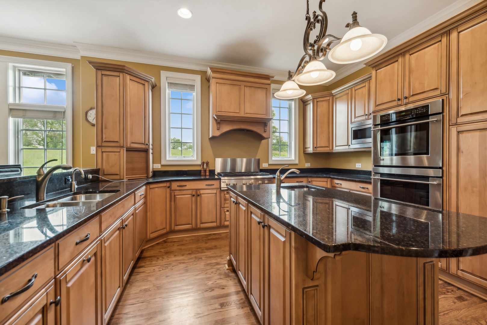 9 Willowcrest Drive, Unit 9 Oak Brook, IL 60523 - Photo 8 of 37 a kitchen with stainless steel appliances granite countertop a sink a stove top oven a chimney cabinets and dining table